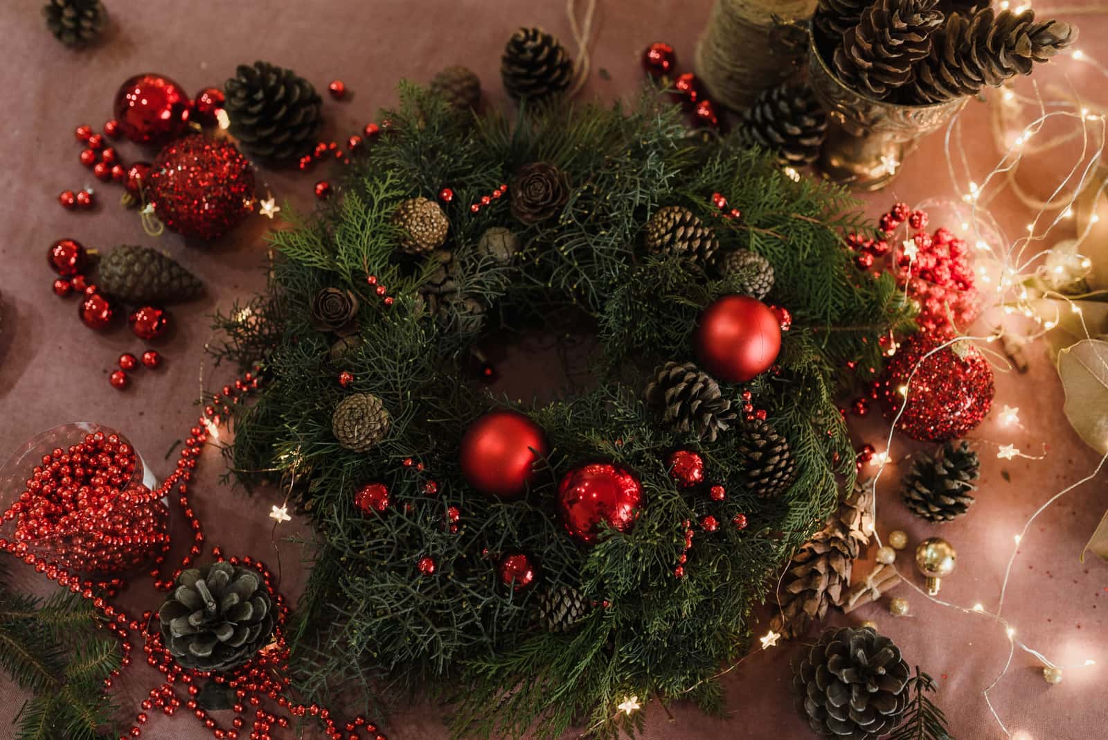 A Christmas wreath lying flat on a wooden table before being packed away